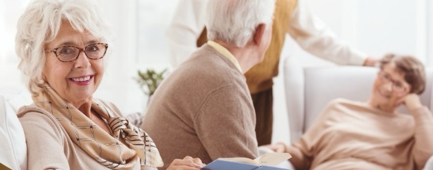Smiling older woman reading at home with companions